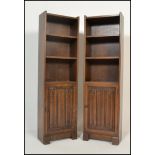 A pair of early 20th century / 1930's oak upright pedestal bookcase cabinets. Each on plinth bases