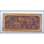 A 19th Century Chinese hand carved wall hanging panel depicting a courtyard scene with red