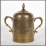 A 20th Century brass Persian lidded pot having repousse and engraved decoration depicting figures