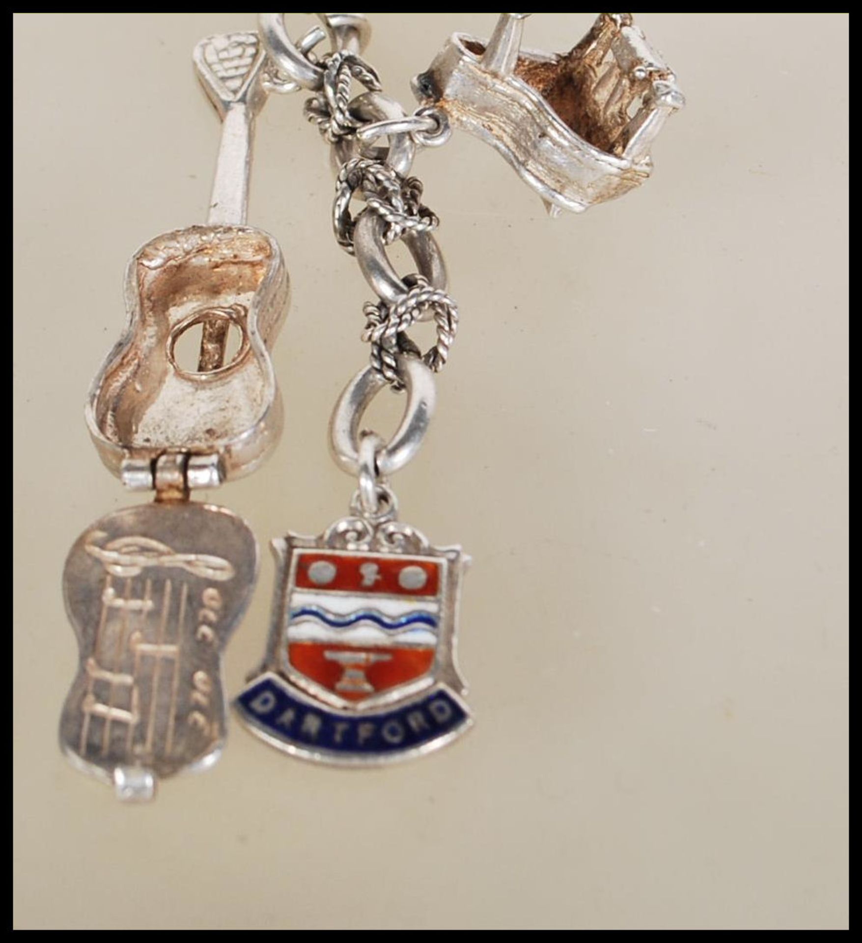 A silver charm bracelet having musical instrument charms to include trumpets, harp, bell violin, - Image 3 of 9