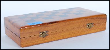 A 20th Century travel chess set having olive wood case opening out into the the chess board.