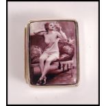 A stamped sterling silver pill box having a enamelled risque image of a woman to the front. Weight