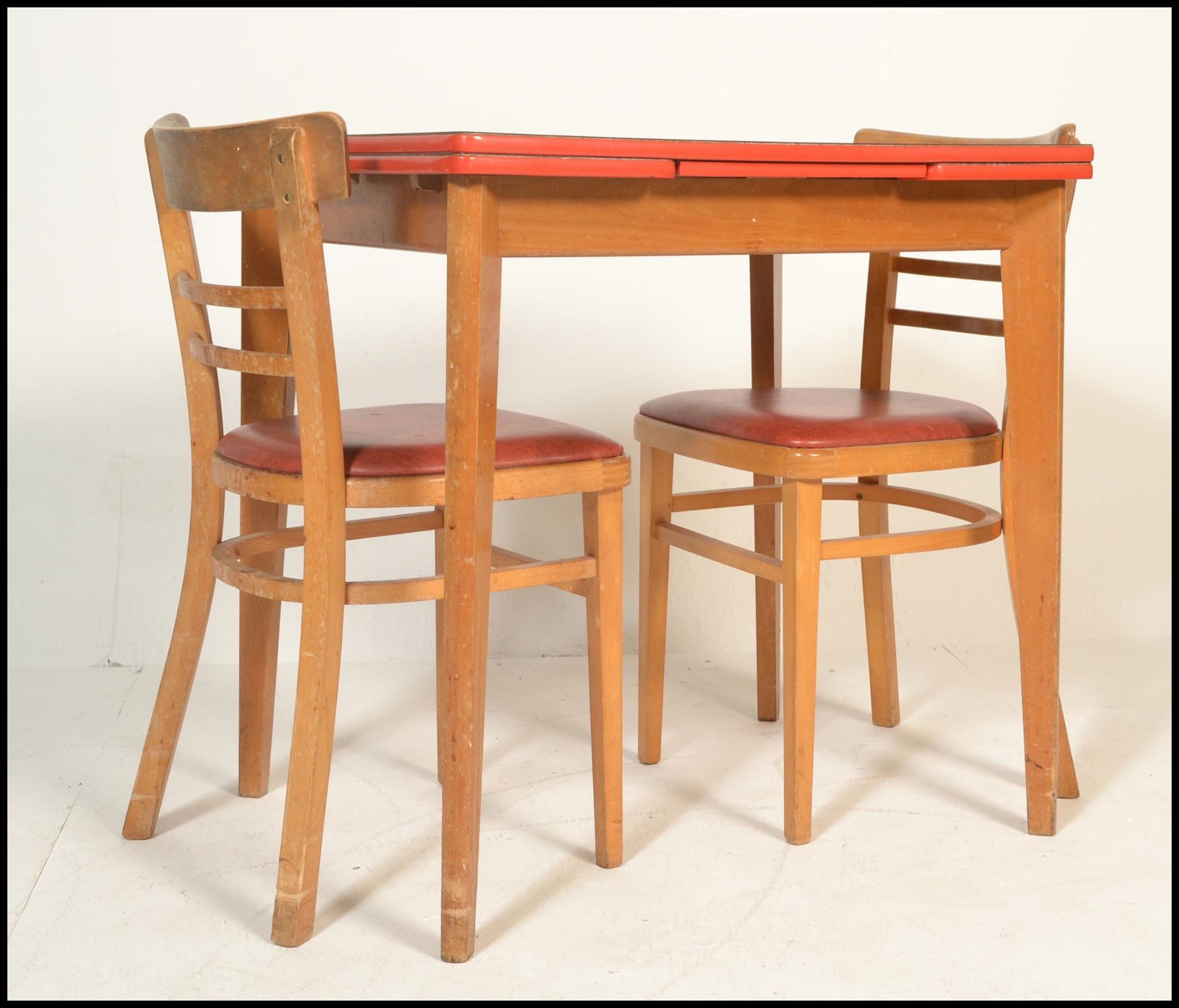 A retro mid century 1950's red formica and beech wood draw leaf dining table. The red formica top