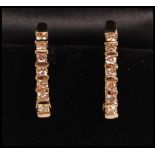 A pair of 14ct gold hoop earrings channel set with round diamonds. Weight 5.7g. Diamonds estimated