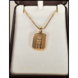 A 9ct gold box link necklace chain set with a gold hallmarked ingot pendant of oblong form having