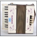 A vintage German Hohner Student accordion with cream veneer. Complete with leather straps. In