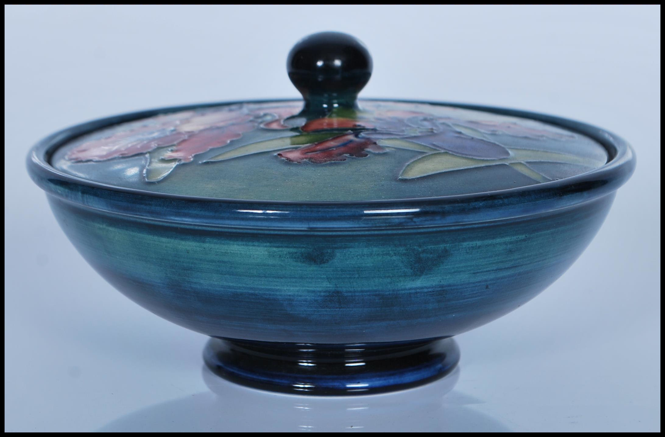 A 20th century Moorcroft blue and green ground  lidded circular dish having a floral ' poppy  '