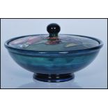 A 20th century Moorcroft blue and green ground  lidded circular dish having a floral ' poppy  '