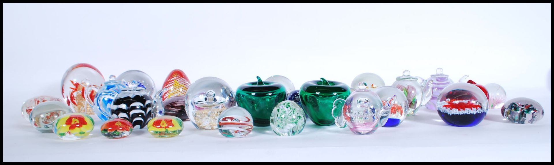 A good collection of 20th Century glass paperweights to include various controlled bubble and