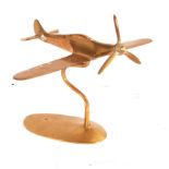 A WWII Second World War era apprentice piece brass model of a Spitfire. Shaped brass stand, with