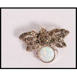 A stamped 925 silver bug brooch being set with a round opal panel and marcasites. Weight 6.2g.