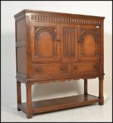 A good quality 17th century revival solid oak court cupboard being raised on block and turned