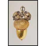 An unmarked Victorian gold pendant in the form of an acorn having a bale to the top with a twin leaf