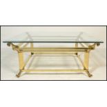 A 20th Century brass and glass top Italian design coffee table of square form raised on scroll