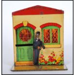 A early 20th Century 1920's / 30's advertising tin money box bank in the form of a house having a