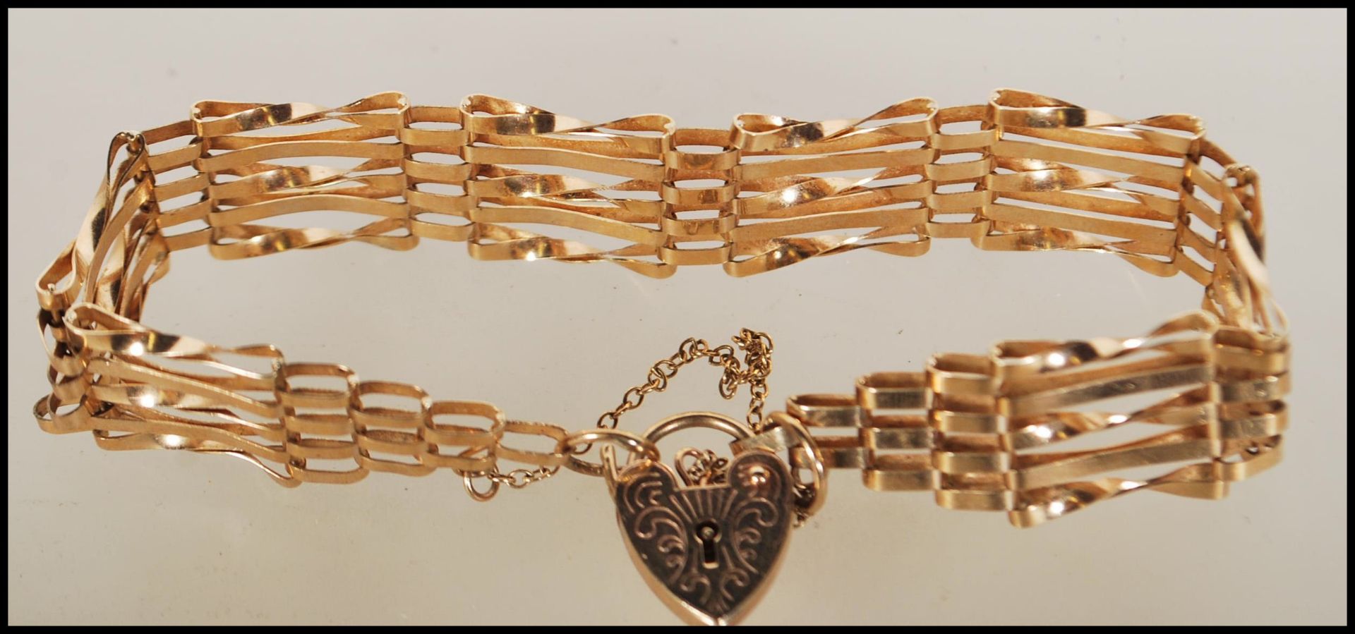 A hallmarked 9ct gold gate bracelet with tapered ends and attached heart-shaped padlock. - Bild 4 aus 5
