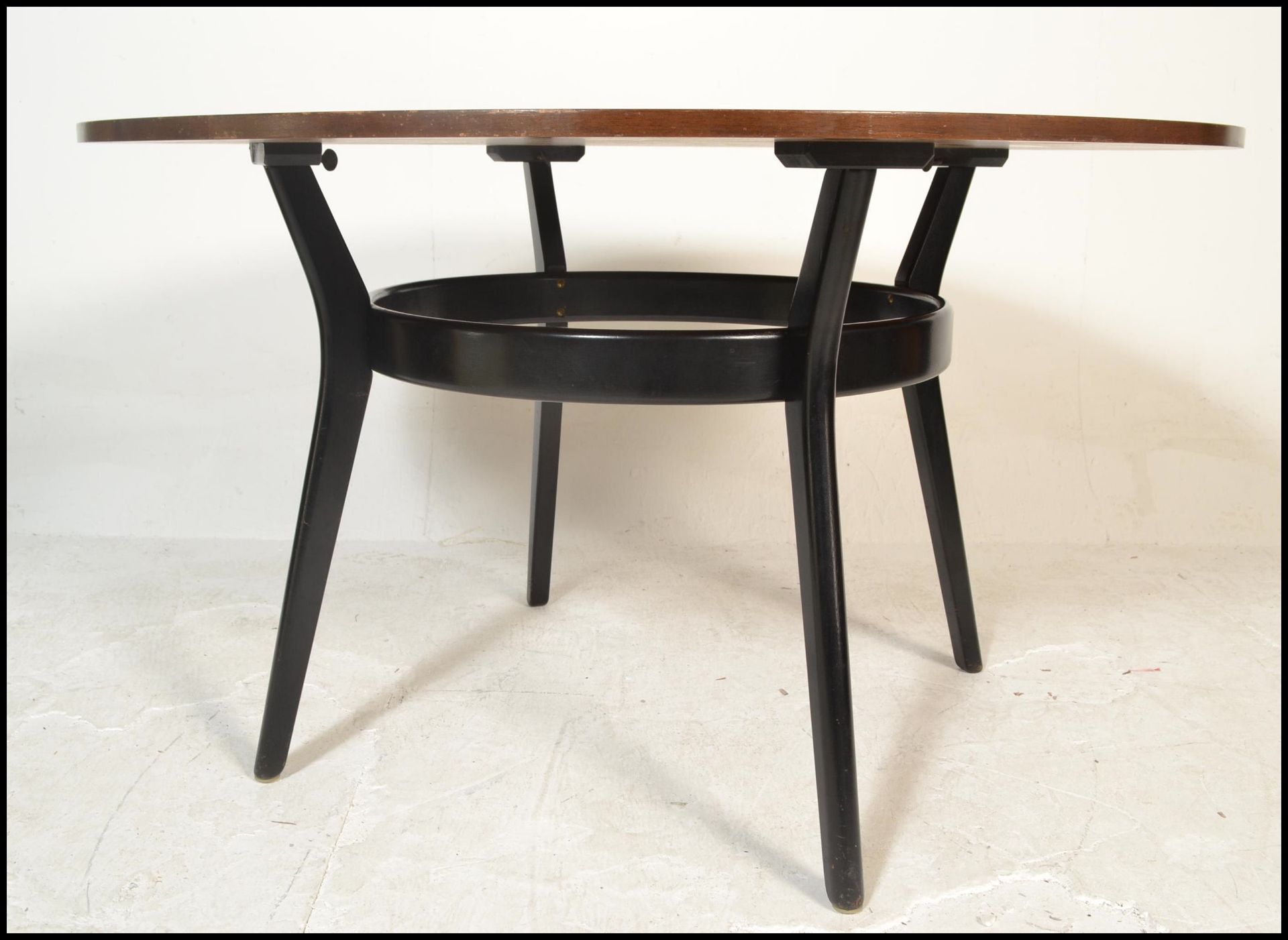 A 20th Century vintage teak wood and ebonised circular dining table  of sputnik / atomic form having