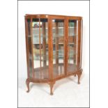 An early 20th Century / 1940's Queen anne revival walnut bow front glazed display cabinet having a