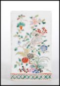 A 19th Century Chinese brush pot of rectangular form being hand painted with floral sprays and