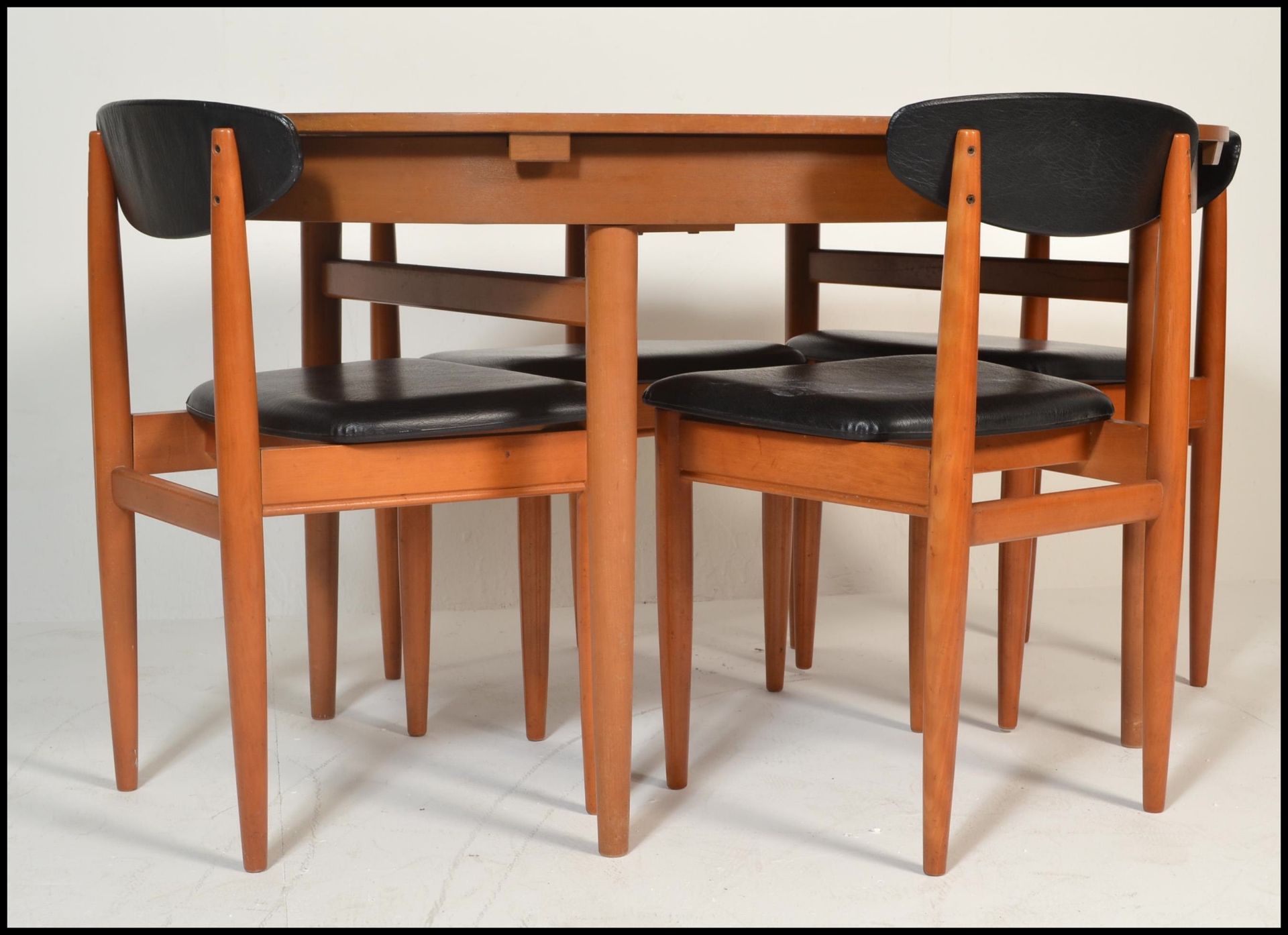 A 20th Century retro 1960's teak wood extending dining table of oval form raised on tapering legs