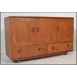 A stunning mid 20th Century Ercol beech and elm Windsor pattern sideboard credenza, three cupboard