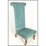 A 19th Century Victorian prie dieu / prayer chair finished in blue velour upholstery having turned