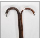 Two early 20th Century walking stick canes having crook handles with silver tips. One being bamboo