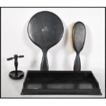 A vintage early 20th Century ebony dressing table set consisting of tray, mirror, hair brush and