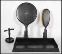 A vintage early 20th Century ebony dressing table set consisting of tray, mirror, hair brush and