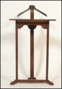 A early 20th Century Edwardian oak valet butlers stand of triangular form having a piece of white