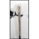 A 20th Century walking stick cane of tapering form having silver white metal embossed foliate
