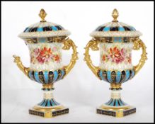 A pair of 19th Century Continental twin handled lidded mantel urns, gilt scroll handles on square