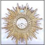 A vintage 20th Century Art Deco style sunburst starburst rising sun wall clock having a gilt