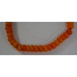 A 20th Century faux amber buddhist prayer bead necklace, strung with red string.