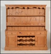 A good quality antique style pine country Welsh dresser. Raised on a plinth base with end