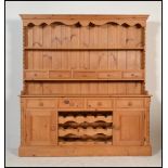 A good quality antique style pine country Welsh dresser. Raised on a plinth base with end
