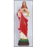 A 20th Century cast resin hand painted figurine in the form of Jesus Christ having a sacred heart to