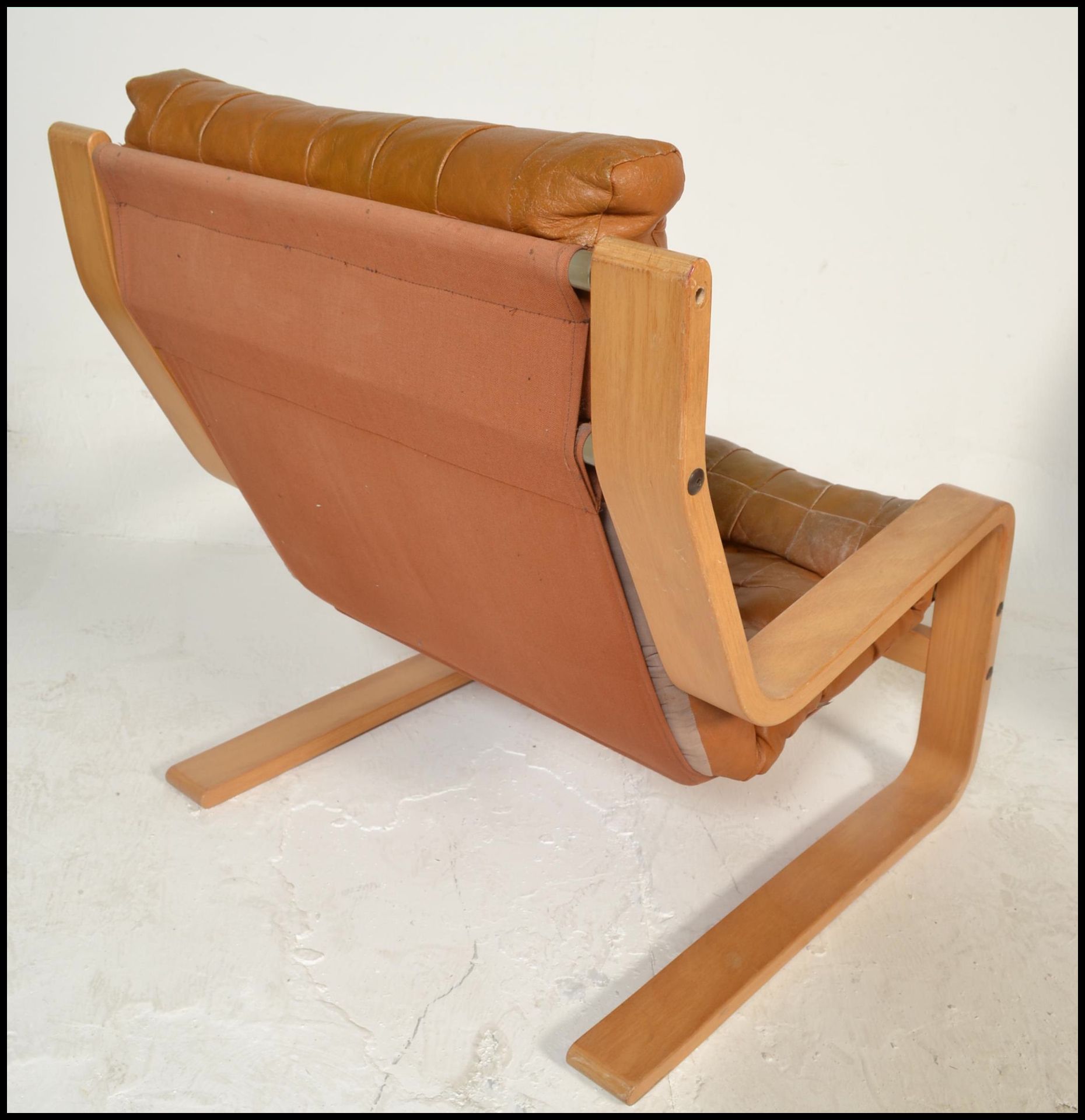 A mid century Danish oxblood leather swivel armchair being raised on a five point chrome base - Bild 3 aus 5
