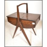 A vintage 20th Century wooden sewing box raised central angular legs with domed handle to the top