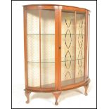 A mid 20th Century bow front mahogany Queen Anne revival display cabinet having glazed panels to the