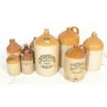 A collection of vintage local interest stoneware advertising flagons of varying sizes to include
