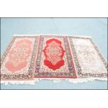 A group of three 20th Century matching floor rug / runners on different coloured grounds, each