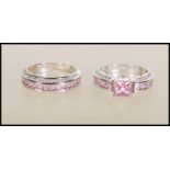A pair of 9ct white gold filled rings to include one band ring set with three rows of pink and white