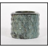 A early 20th Century Chinese mottled dark green jade archer's thumb ring, having ribbed nobly