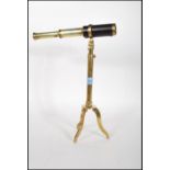 A vintage 20th Century brass table / desk top telescope being leather bound and raised on a brass