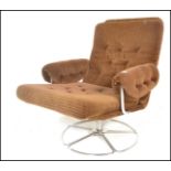 A mid century retro Danish influenced swivel easy armchair being upholstered in the original