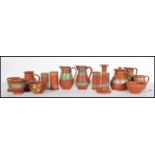 A collection of late 19th Century Terracotta Pratt ware consisting of  prattware jugs, cylindrical