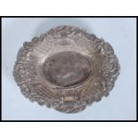 A 20th Century silver hallmarked pin dish of oval form having swirl and foliate embossed relief