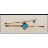 A 9ct gold and black opal doublet ladies bar brooch. The brooch with twin bar, central cabochon opal