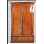 A Victorian mahogany double wardrobe armoire being raised on a plinth base having single drawer with